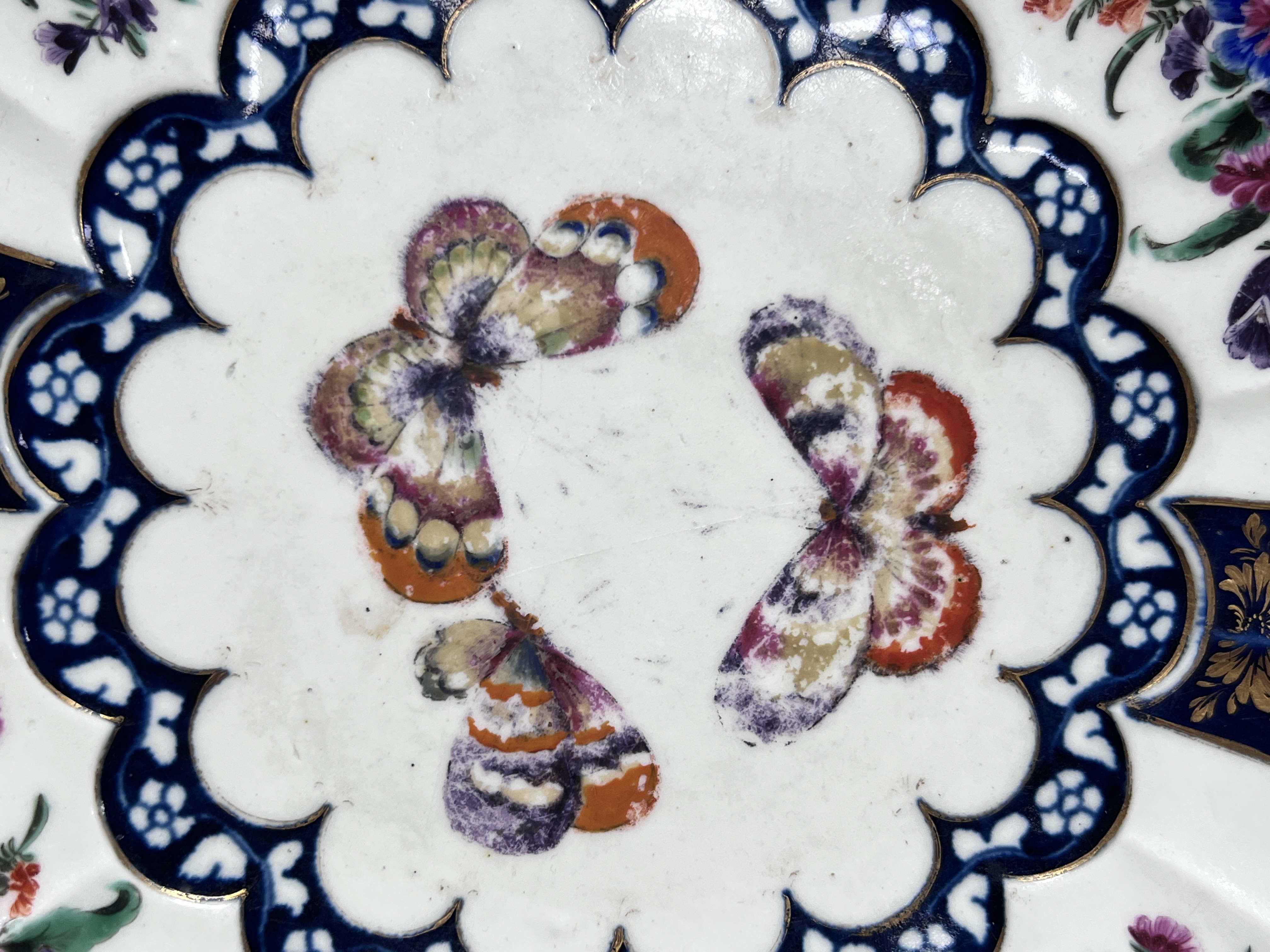 A Worcester fluted dish painted with butterflies and flowers in the manner of James Giles, seal mark, c.1770, 26cm diameter